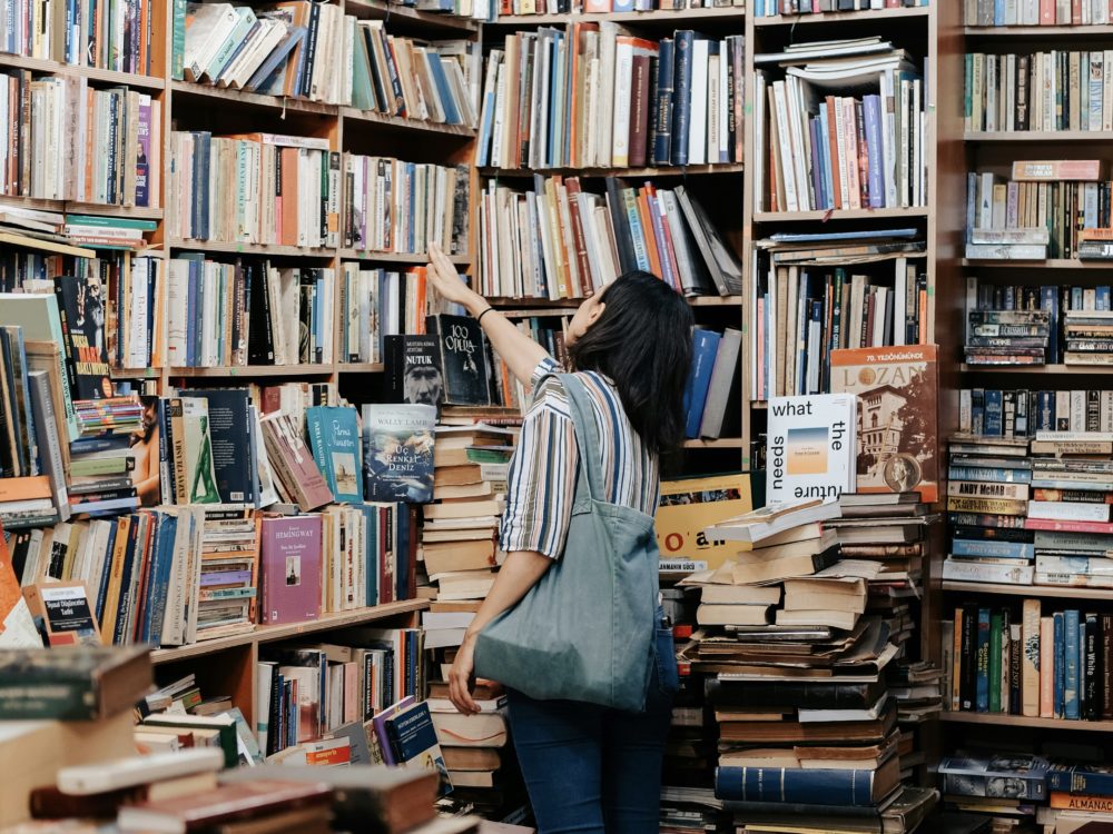 本棚の前で書籍を探す女性