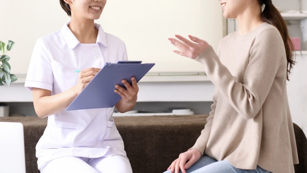 笑顔でカウンセリングする看護師と相談に来た女性