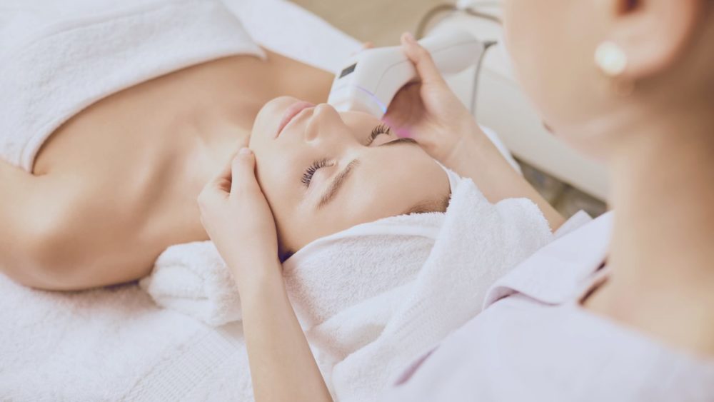 美容機器で肌のケアをしている女性と、美容機器を肌に当てる看護師